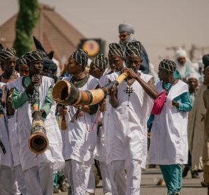 Festive parade in Nigeria featuring traditional attire and musical performances.